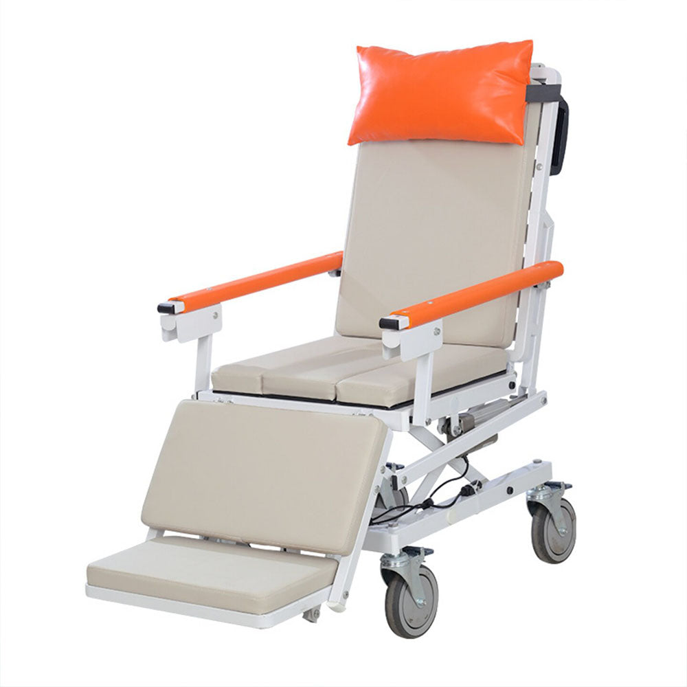 Horizontal electric patient transfer chair shown empty at a three-quarter angle with orange head pillow and armrests, padded leg rest extended and four locking casters, on a white background
