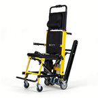 Yellow and black stair climbing wheelchair fully unfolded at a three-quarter angle, showing the padded headrest, mesh backrest, flip-up armrests, footrest and rubber climbing track
